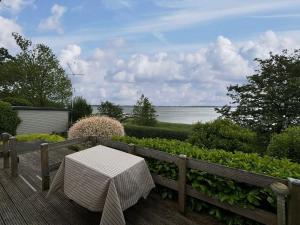 une terrasse en bois avec un banc et une table dans l'établissement Coast Seven, à Borgwedel