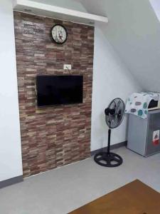 a brick fireplace with a clock and a fan at Quiin Home cozy modern house in Pampang +42 photos