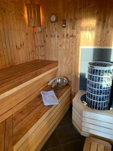 una sauna de madera con bañera y fregadero en Cozy cottages with sauna in Öland, en Mörbylånga