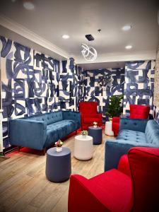 a living room with blue couches and red chairs at Royal Oak Inn in Toronto