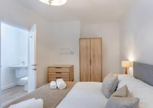 阿尔弗斯顿Lonsdale House Boutique Apartments的一间卧室，床上有两条白毛巾