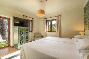 a bedroom with a large white bed and a window at Hotel Quinta Do Furao in Santana