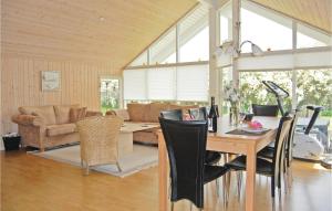 a dining room and living room with a table and chairs at Holiday Home Bogo By 34 With Hot Tub in Bogø By