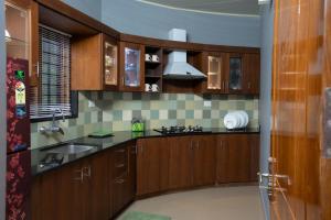 a kitchen with wooden cabinets and a sink at Pine Escape By Cluster Cloud in Pīrmed