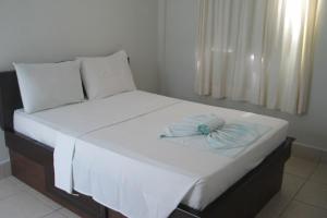 帕劳阿佩巴斯Serrano Park Hotel的一张带白色床单和蓝色带子的床