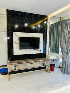 a large entertainment center with a large television in a living room at Hayat Grand Guest House in Islamabad
