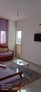 ein Wohnzimmer mit einem Tisch und einem Sofa in der Unterkunft Dar MORTADA TATAOUINE in Tataouine