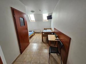 a small room with a table and a room with a bed at Noclegi Wega in Częstochowa