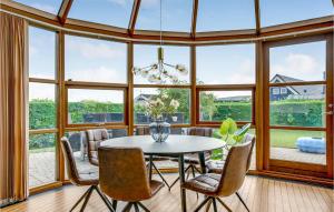 a dining room with a table and chairs and large windows at Two-Bedroom Holiday Home In Hejls in Hejls