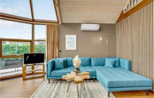 a living room with a blue couch and a tv at Two-Bedroom Holiday Home In Hejls in Hejls