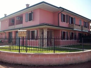 une maison rose avec une clôture devant elle dans l'établissement Al Calypso, à Curtatone