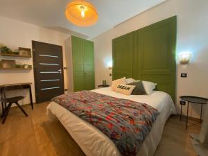 a bedroom with a bed with green cabinets and a table at Maison paisible proche du centre in Besançon