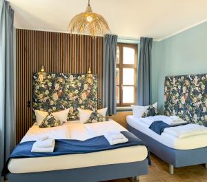 two beds in a room with blue walls at Villa Fantasia Budget Boutique Hotel in Füssen