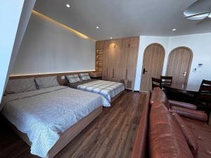 a bedroom with two beds and a couch and a table at Wabi Homes in Buon Ma Thuot