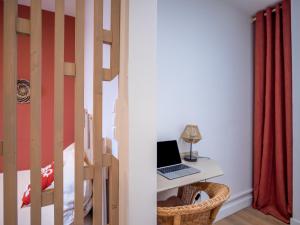 einen Laptop auf einem Schreibtisch in einem Schlafzimmer in der Unterkunft Le Cosy Express in Villefranche-sur-Saône