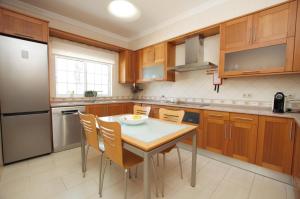 Una cocina con gabinetes de madera y una mesa y sillas. en Villa Perla by Vintage Travel, en Guia