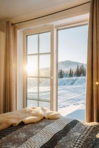 a bedroom with a window with a view of snow at 2 bedroom`s with bathroom and full kitchen in Borgafjäll