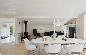 a dining room and living room with a white table and chairs at Nice Home In Juelsminde With Kitchen in Juelsminde