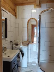 a bathroom with a washing machine and a sink at Widokowe Domki Kościelisko in Kościelisko