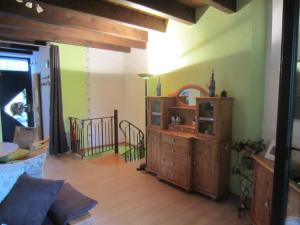 ein Wohnzimmer mit einer Holzkommode und einer Treppe in der Unterkunft FeWo im Studio Wintergarten in Kallstadt