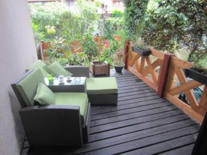 a wooden deck with chairs and a table on it at FeWo im Studio Wintergarten in Kallstadt