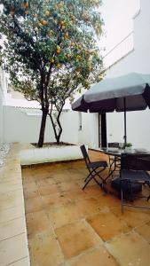 a table and chair and an umbrella next to a tree at Sherryflat Jerez Centro in Jerez de la Frontera