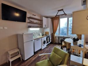 a kitchen and living room with a table and chairs at Апартамент Център in Vratsa