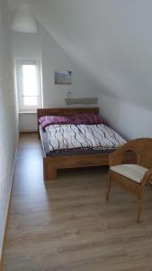 Un dormitorio con una cama y una silla y una ventana. en Das Landhaus Wohnung 2, en Kirch Mulsow