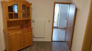 Habitación con armario de madera y puerta que da a un pasillo. en Das Landhaus Wohnung 2, en Kirch Mulsow