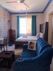 una sala de estar con un sofá y una cama en midenlavin studio Airbnb, en Mombasa