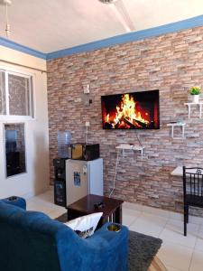 sala de estar con pared de ladrillo y chimenea en midenlavin studio Airbnb, en Mombasa