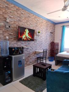 sala de estar con TV en una pared de ladrillo en midenlavin studio Airbnb, en Mombasa