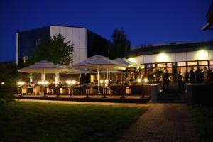 a group of tables with umbrellas in front of a building at Hotel Kongresowy in Kielce