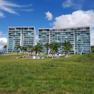 a large building with palm trees in front of it at Paraiso Caribeño 706 in Colón