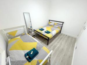 South NorwoodにあるNEW 5-bedroom house in Croydon South Londonのベッド2台と鏡のある寝室