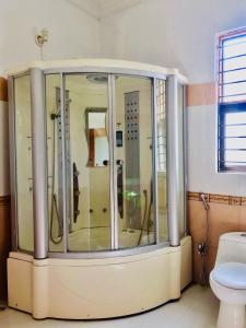 a glass shower in a bathroom with a toilet at Hayat Grand Guest House in Islamabad