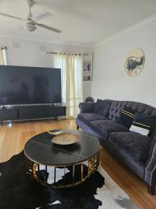 a living room with a couch and a table at Cozy Escape in Sunbury +2 photos