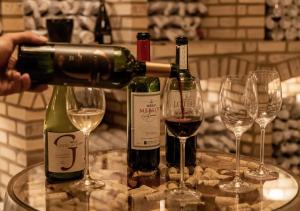a person pouring wine into two wine glasses at Apartamento no Centro de Bento Gonçalves in Bento Gonçalves