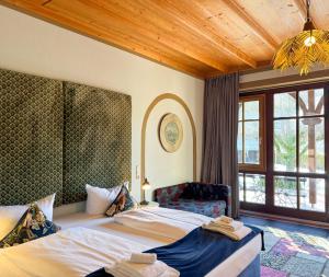 a bedroom with two beds and a large window at Villa Fantasia Budget Boutique Hotel in Füssen