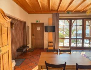 a living room with a table and chairs and a room with windows at Villa Fantasia Budget Boutique Hotel in Füssen