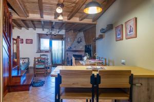 a kitchen and living room with wooden ceilings and a table at Villa El Retiro Un Alojamiento con Encanto in Mediavilla