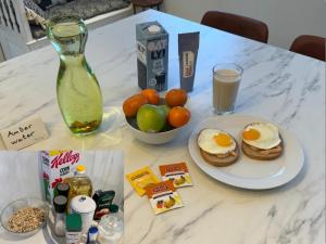 a table with a plate of breakfast foods and a bottle of milk at Just Like Home Bed & Spa Porsgrunn in Porsgrunn