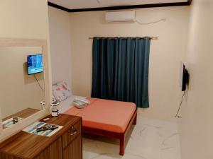 a bathroom with a bed and a blue curtain at K.Y.M Pension House in Moalboal
