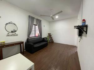 a living room with a black chair and a mirror at Laman Hanaz - Homestay Aufa in Pantai Cenang