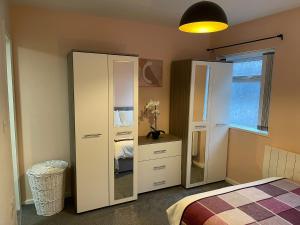 a bedroom with a white cabinet and a mirror at Coronation Court in Stoke on Trent