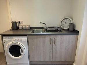 a kitchen with a sink and a washing machine at Coronation Court in Stoke on Trent +1 photo