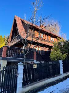 a house with a black fence in front of it at PEŁNA CHATA w Gródku nad Dunajcem in Gródek Nad Dunajcem +61 photos