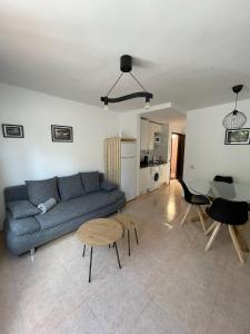 a living room with a blue couch and a table at Appartement près de la plage in Corralejo
