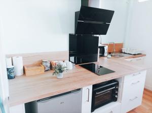 a kitchen with a wooden counter top with a microwave at Bel appartement tout équipé in Le Mans +4 photos