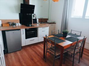 a kitchen with a table with chairs and a microwave at Bel appartement tout équipé in Le Mans
